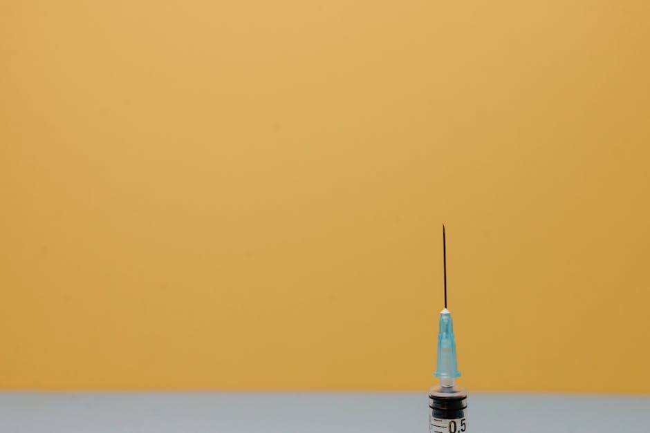Close-up of a medical syringe against a vivid yellow background, ideal for healthcare themes.