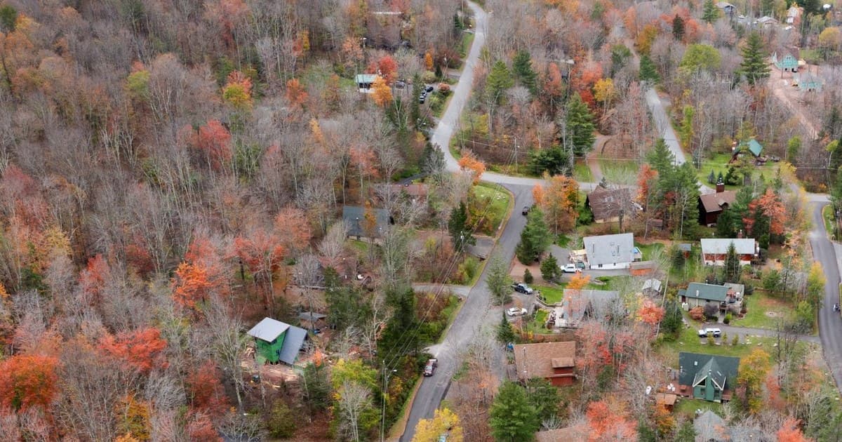 Picturesque aerial view of Catskill, New York, featuring vibrant autumn foliage and cozy rural homes.