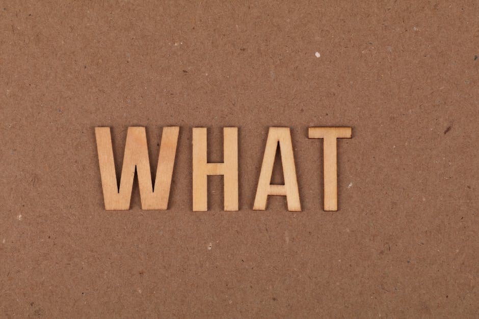 Wooden letters spelling 'What' on a brown cardboard background, close-up view.
